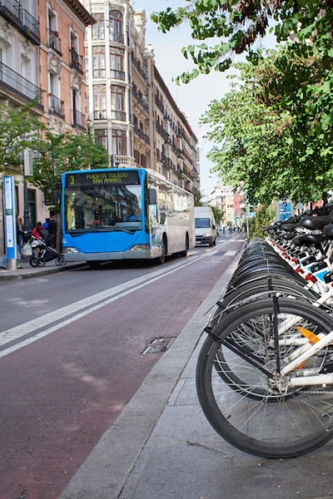 row of shared bike rentals with a bus in the background - public transportation